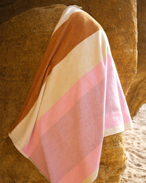 Striped towel draped over a rock with a natural background